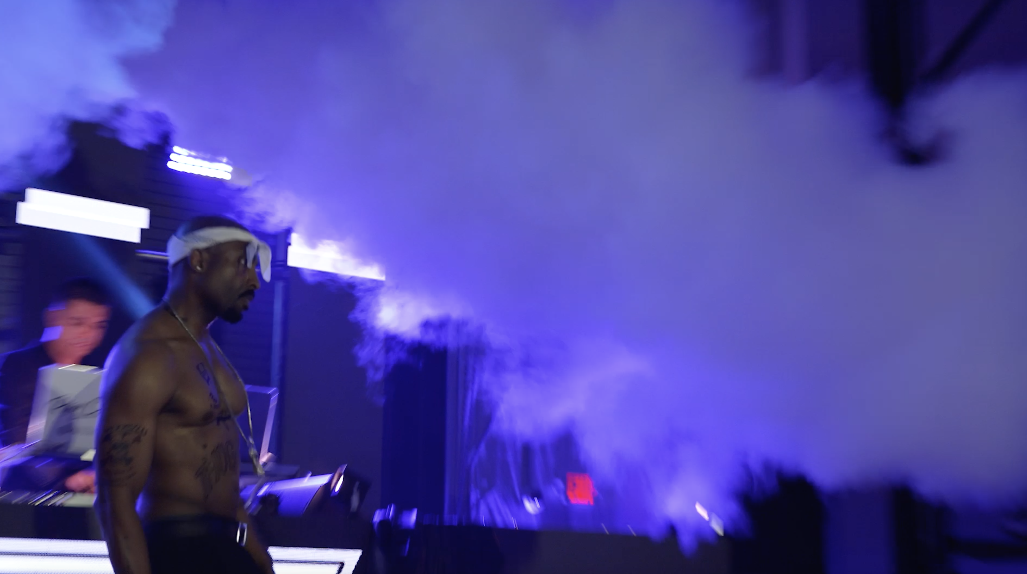 Josh Harraway as Tupac with blue stage smoke and open negative space