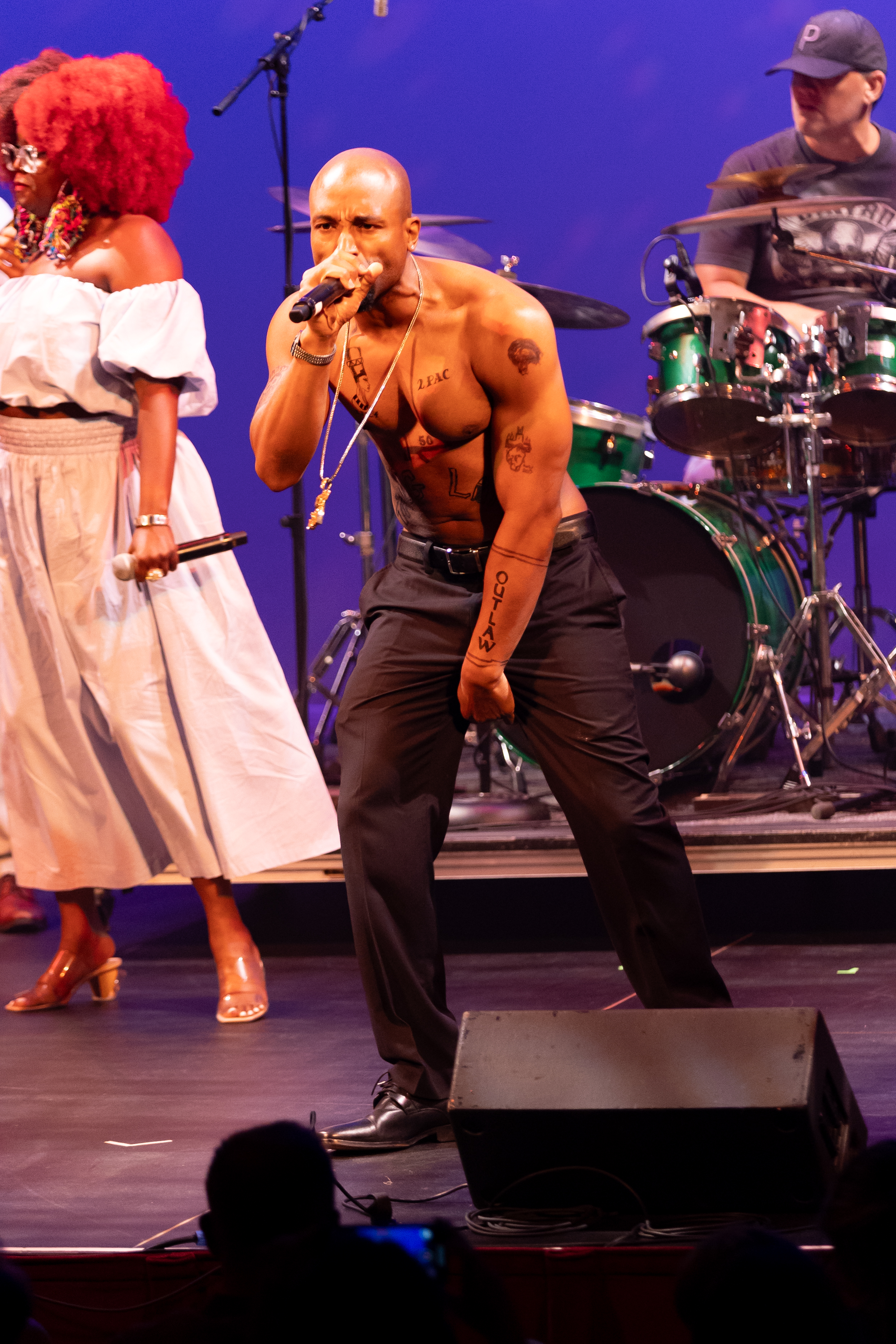 Josh Harraway as Tupac in an intense shirtless stage performance pose