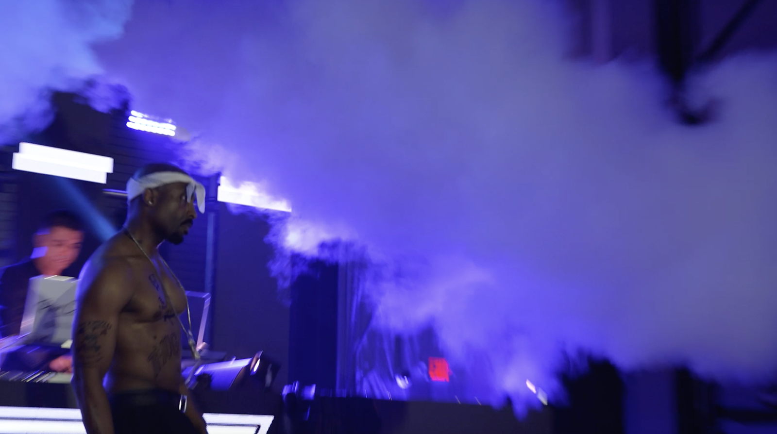 Josh Harraway as Tupac with blue stage smoke and open negative space