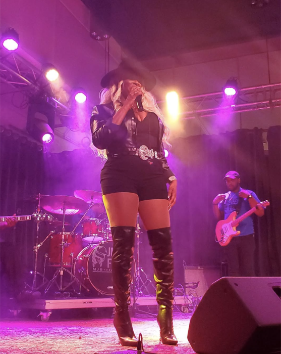 Tre’Jae performing under purple stage lights