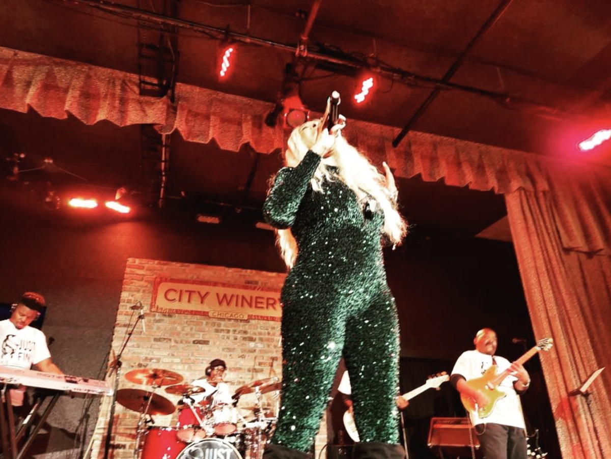 Tre’Jae performing under red stage lights